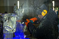 Ice spray / African sculptor working away with a power tool creating a spray of ice