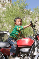 Boy on motor bike / Young boy playing on a parked motor bike
