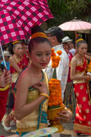 Flower girl under umbrella / Religious procession for Lao New Year in Luang Prabang and following celebrations