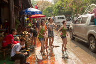 Young girls throwing water / Religious procession for Lao New Year in Luang Prabang and following celebrations