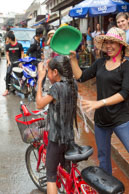 Young girl being soaked / Religious procession for Lao New Year in Luang Prabang and following celebrations