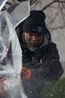 Ice Sculptor at work / Member of the African team shaping their scuplture with a chain saw