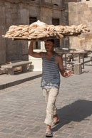 Delivering bread / Man carrying a tray of bread through Islamic Cairo