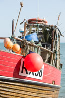Fishing Boat & Buoy / A large buoy hanging over the side of a fishing boat