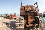 Bulldozer and fishing boats / One of the bulldozers with a number of fishing boats in the background