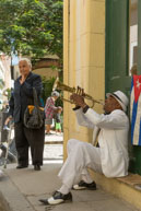 Trumpet Player / A Cuban trumpet player on a street corner in Havana with an elderly woman looking on