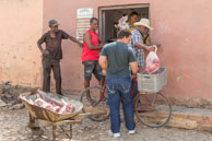 More meat! / More meat is delivered to the Cuban Butcher in a wheel barrow whilst a purchase goes on the back of a bicycle