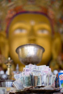 Offerring and Buddha / Offerring of money in front of the statue of Buddha