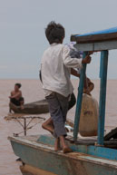Boy refuelling boat / Experiences when travelling through villages in Cambodia