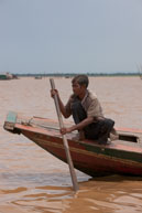 Man steering boat / Experiences when travelling through villages in Cambodia