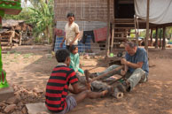 Photographer helping to saw wood / Experiences when travelling through villages in Cambodia